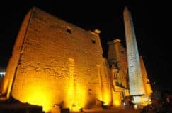 Entrance of the Luxor Temple at night in Egypt with the first pylon and obelisk