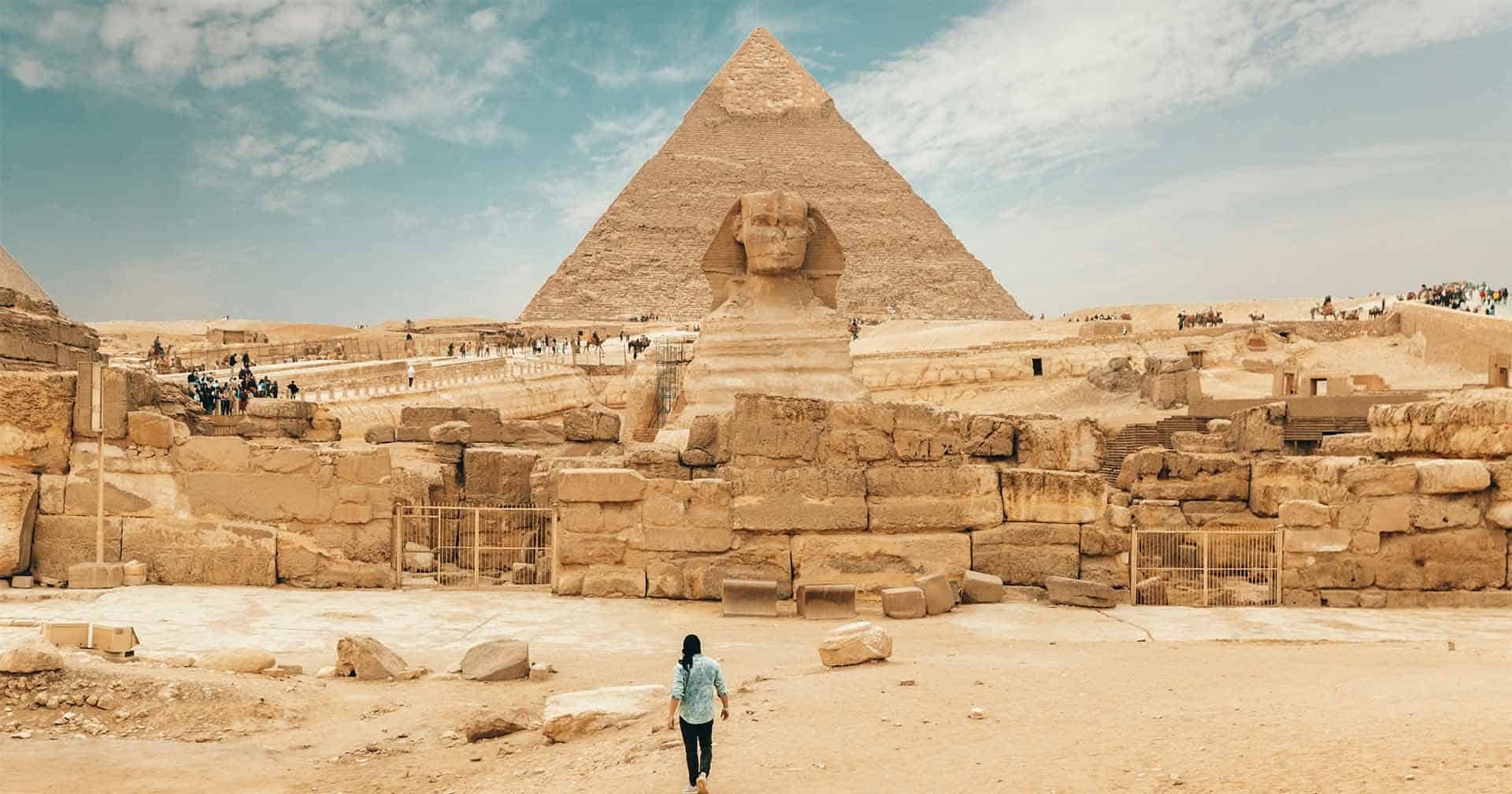 Traveler approaching the Sphinx and Pyramid of Giza in Egypt on a luxury custom tour with Osiris Tours